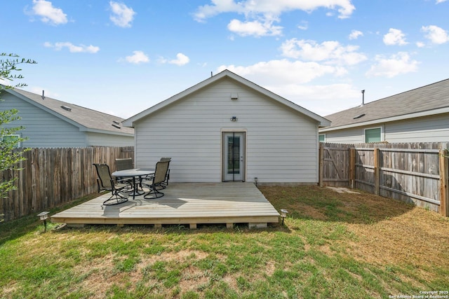 rear view of house featuring a lawn, a fenced backyard, and a wooden deck