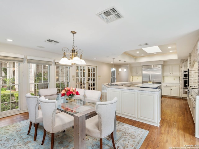 10 Parman Pl, San Antonio, TX 78230 - dining space featuring light wood finished floors, a raised ceiling, recessed lighting, and a chandelier