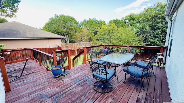 wooden terrace featuring outdoor dining area and fence