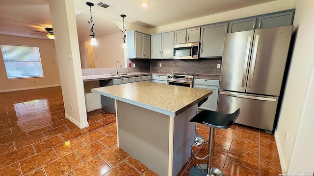 kitchen with visible vents, decorative backsplash, appliances with stainless steel finishes, decorative light fixtures, and a sink