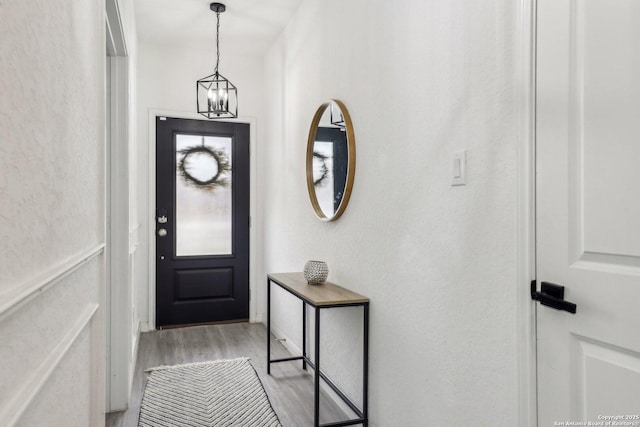 foyer featuring light wood finished floors and an inviting chandelier