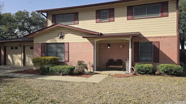 traditional-style home with brick siding, driveway, and an attached garage