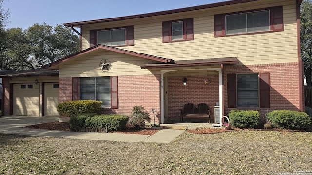 view of front of home featuring covered porch, brick siding, and an attached garage