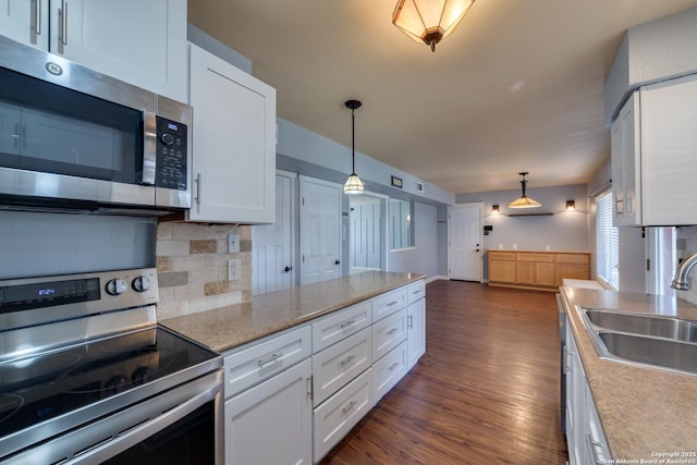 kitchen featuring decorative backsplash, white cabinets, dark wood-style floors, appliances with stainless steel finishes, and a sink