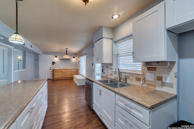 kitchen featuring dark wood-style flooring, backsplash, stainless steel dishwasher, white cabinetry, and a sink