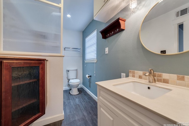 bathroom featuring toilet, wood finished floors, visible vents, vanity, and baseboards