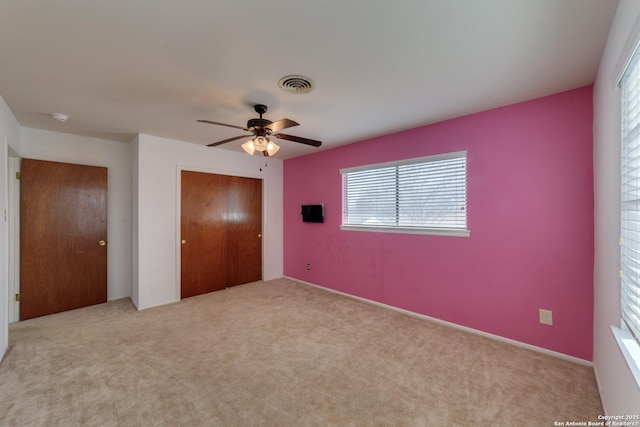 unfurnished bedroom featuring carpet floors, a closet, visible vents, and ceiling fan