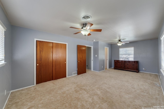 unfurnished bedroom with baseboards, visible vents, ceiling fan, and carpet flooring