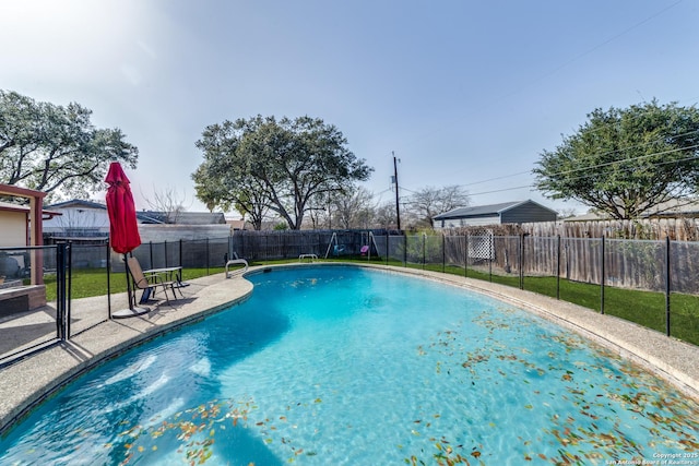 view of swimming pool with a yard, a fenced in pool, a fenced backyard, and a patio