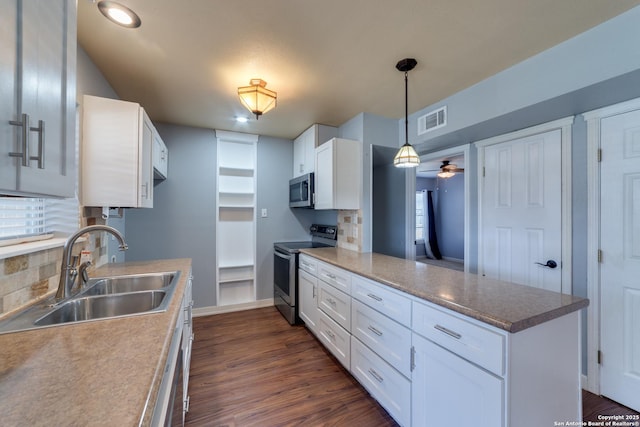 kitchen featuring a peninsula, a sink, visible vents, white cabinetry, and appliances with stainless steel finishes