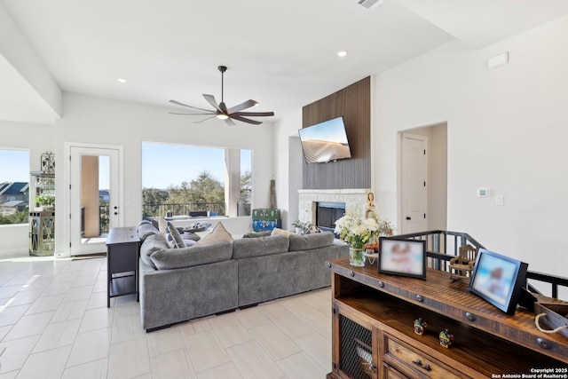 living area with a ceiling fan, recessed lighting, and a fireplace