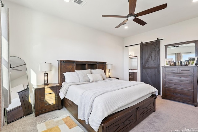 bedroom with recessed lighting, light colored carpet, visible vents, a barn door, and ensuite bath