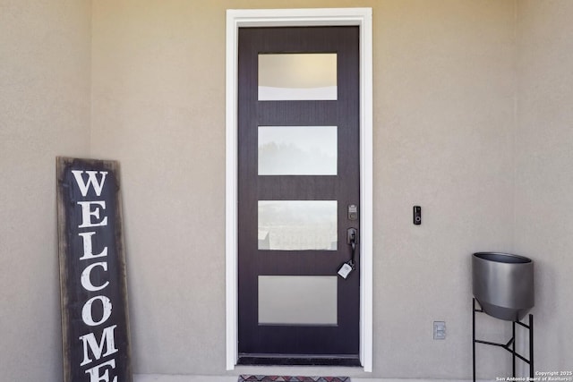 doorway to property with stucco siding