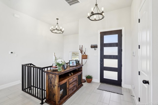 entryway featuring an inviting chandelier, baseboards, and visible vents