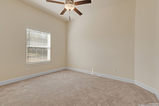 empty room featuring a ceiling fan, light colored carpet, and baseboards