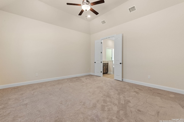 spare room with a ceiling fan, light colored carpet, visible vents, and baseboards