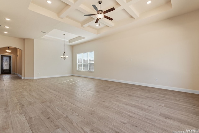 unfurnished room with arched walkways, coffered ceiling, light wood-style flooring, and baseboards