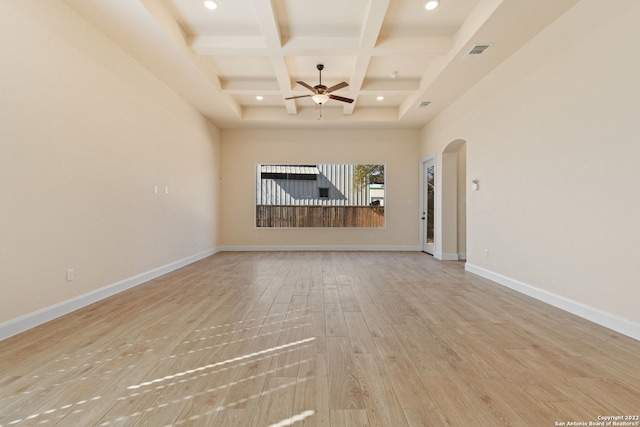 unfurnished room featuring arched walkways, coffered ceiling, visible vents, baseboards, and light wood finished floors