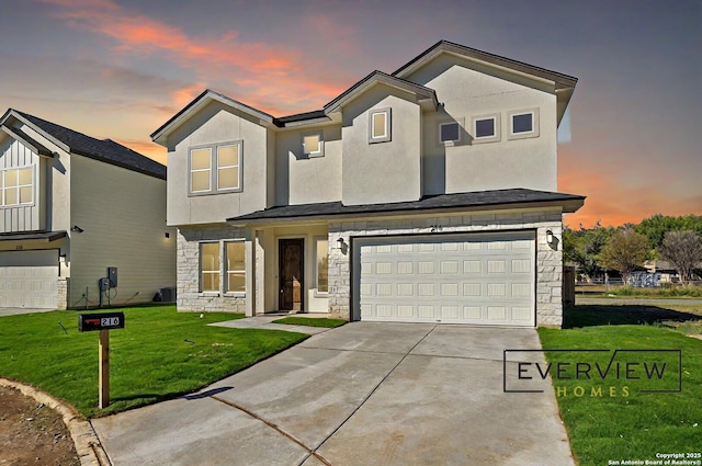 view of front of home featuring stucco siding, a lawn, a garage, stone siding, and driveway