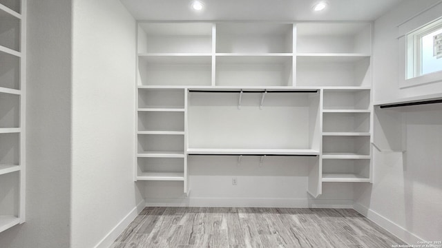 walk in closet with wood finished floors