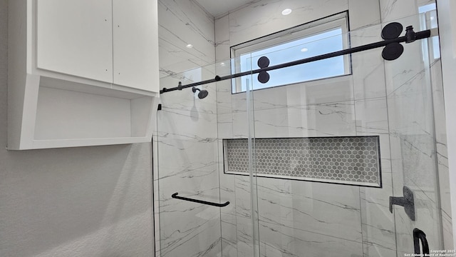 full bathroom featuring a marble finish shower