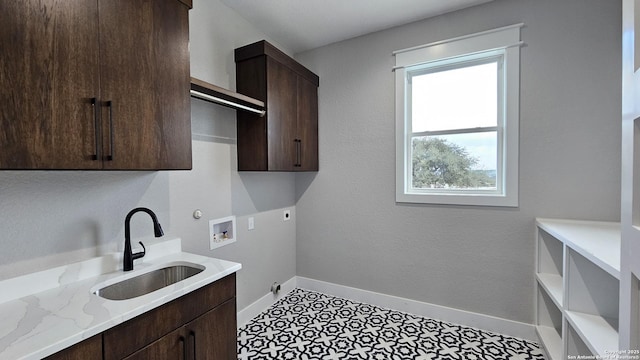 laundry room with cabinet space, baseboards, hookup for a washing machine, hookup for an electric dryer, and a sink