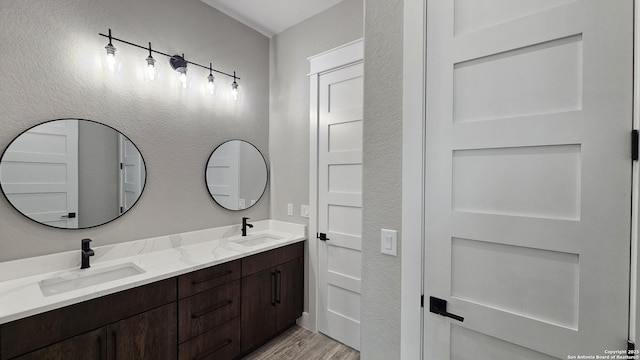 bathroom featuring double vanity, a sink, and wood finished floors