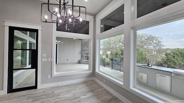 unfurnished sunroom with an inviting chandelier and a sink