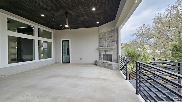 view of patio featuring ceiling fan and an outdoor stone fireplace