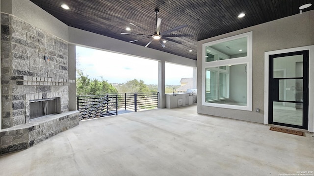 view of patio / terrace with an outdoor stone fireplace, ceiling fan, and a sink