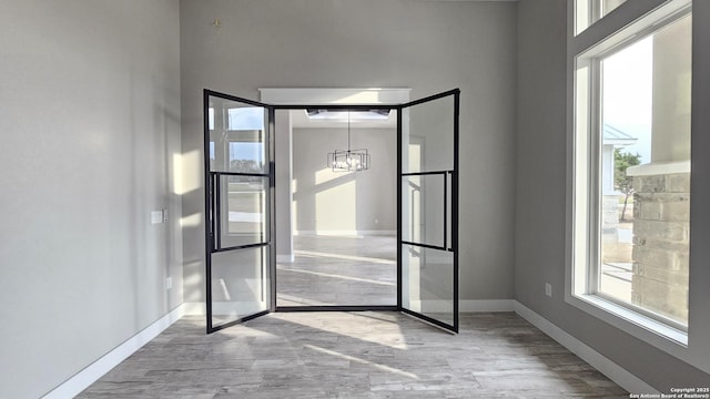 interior space featuring a chandelier, baseboards, and wood finished floors