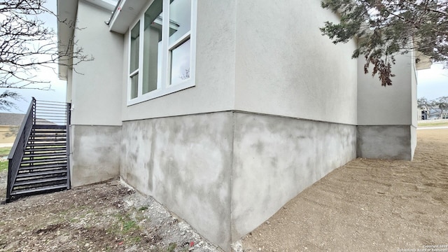 view of property exterior with stairs and stucco siding