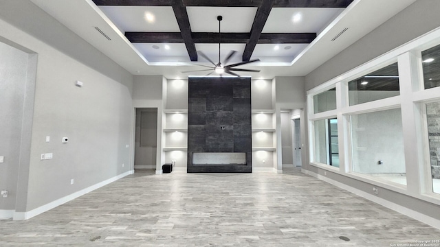 unfurnished living room featuring visible vents, a towering ceiling, a tiled fireplace, coffered ceiling, and baseboards