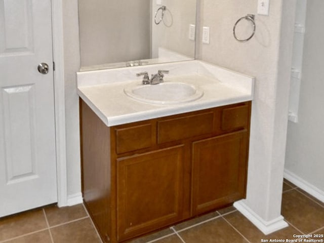 bathroom with vanity, baseboards, and tile patterned floors