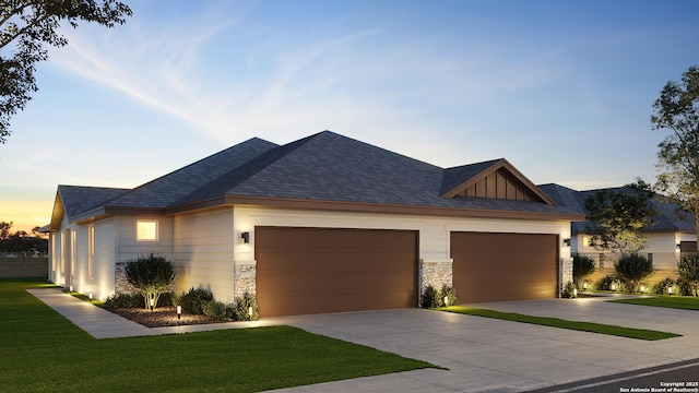 view of front facade with a garage, concrete driveway, stone siding, a front lawn, and board and batten siding