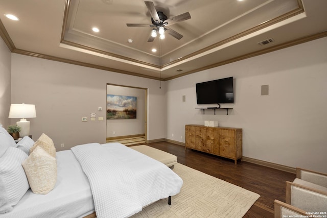 bedroom featuring baseboards, visible vents, a raised ceiling, dark wood finished floors, and crown molding