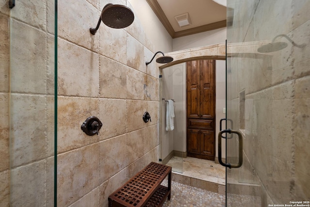 bathroom with ornamental molding, a stall shower, and visible vents