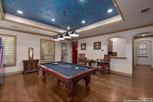 rec room with arched walkways, wood finished floors, and a raised ceiling