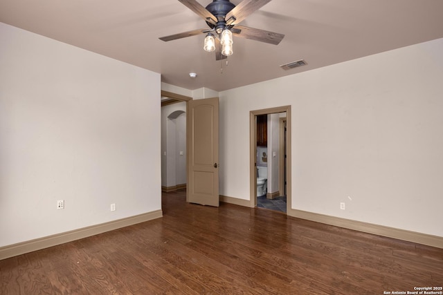 unfurnished room featuring baseboards, visible vents, ceiling fan, and wood finished floors