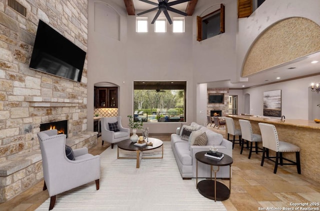 living room with recessed lighting, stone finish flooring, visible vents, and a stone fireplace