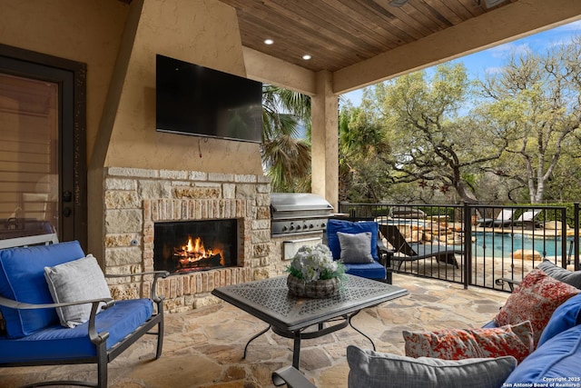 view of patio with area for grilling and an outdoor living space with a fireplace