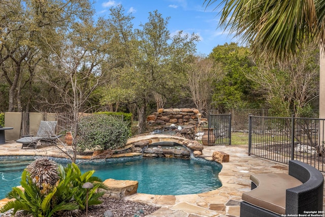 view of pool with a hot tub, fence, a fenced in pool, and a patio