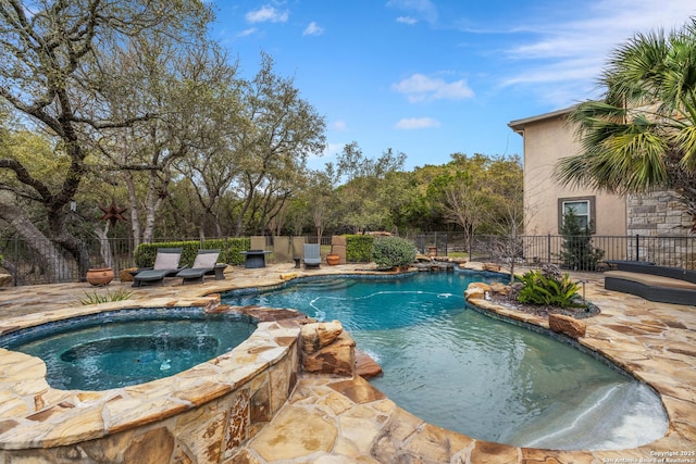 view of swimming pool featuring an in ground hot tub, a patio area, fence, and a fenced in pool