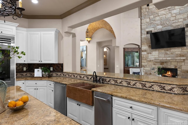 kitchen with crown molding, white cabinets, dishwasher, and tasteful backsplash