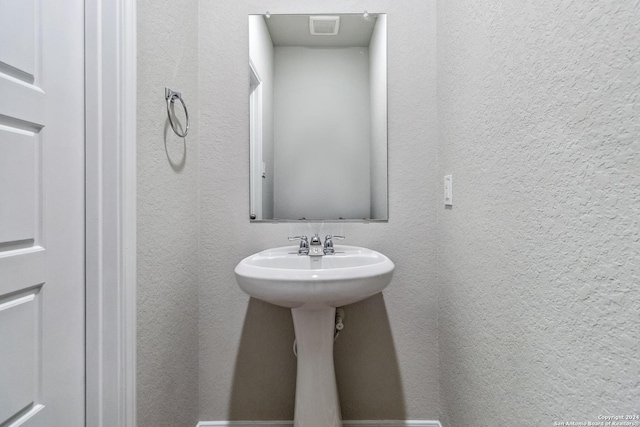 bathroom featuring a textured wall