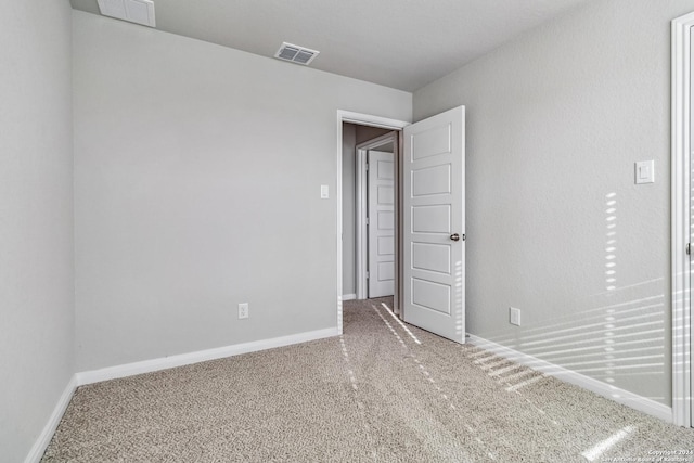 unfurnished bedroom with carpet flooring, visible vents, and baseboards