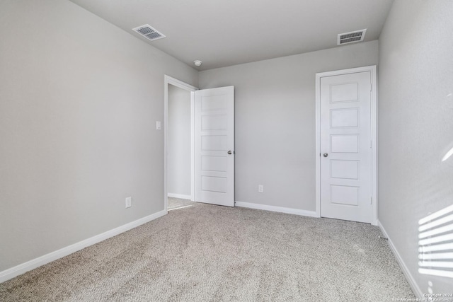 unfurnished bedroom featuring carpet, visible vents, and baseboards