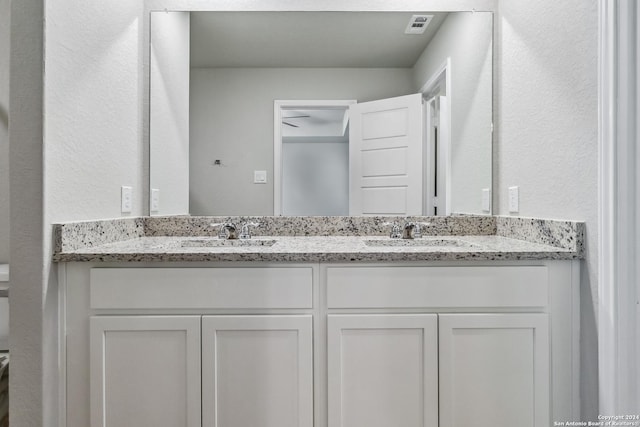 full bath with double vanity, a sink, and visible vents