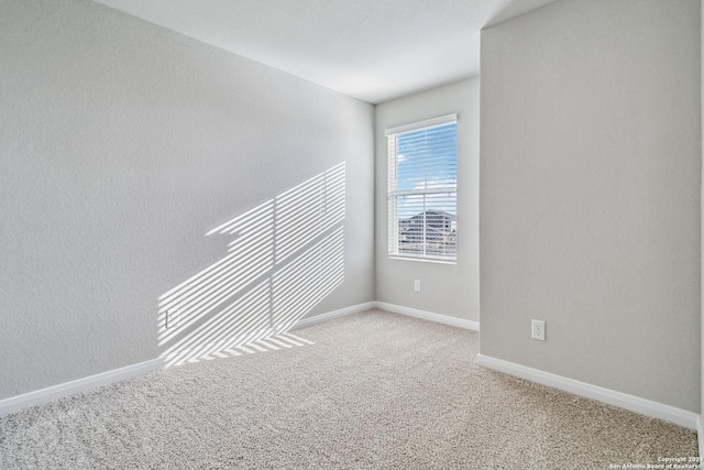 empty room featuring carpet flooring and baseboards