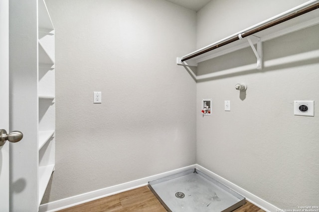 laundry area with hookup for a washing machine, hookup for an electric dryer, wood finished floors, laundry area, and baseboards